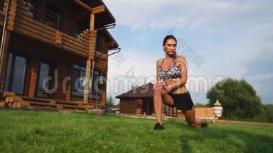 一位身材苗条、穿着运动服的美女正准备在家附近的草坪上开始训练